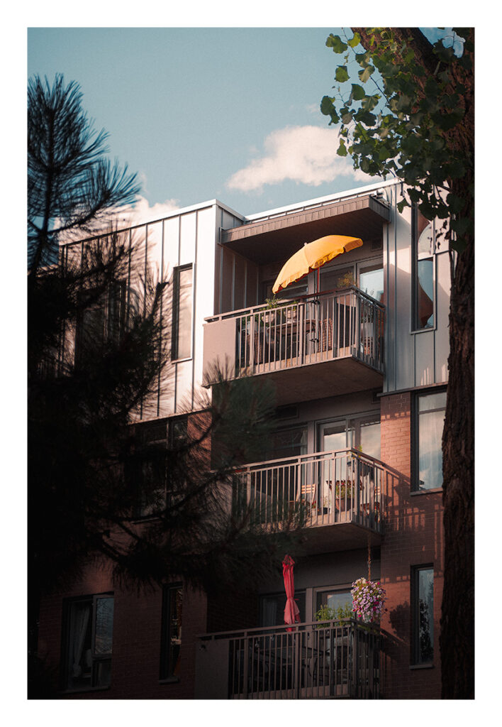 Un bâtiment avec balcon et parasol.